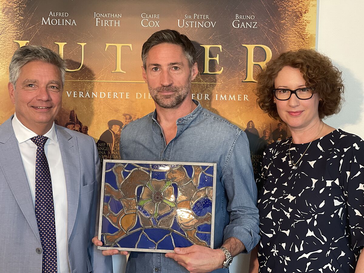 Alexander Thies, Benjamin Sadler with the LutherRose award symbol and Henriette Gotaut. © Clara von Fürstenberg / NFP